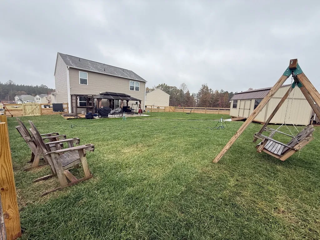 Newly laid sod in a backyard with a playset